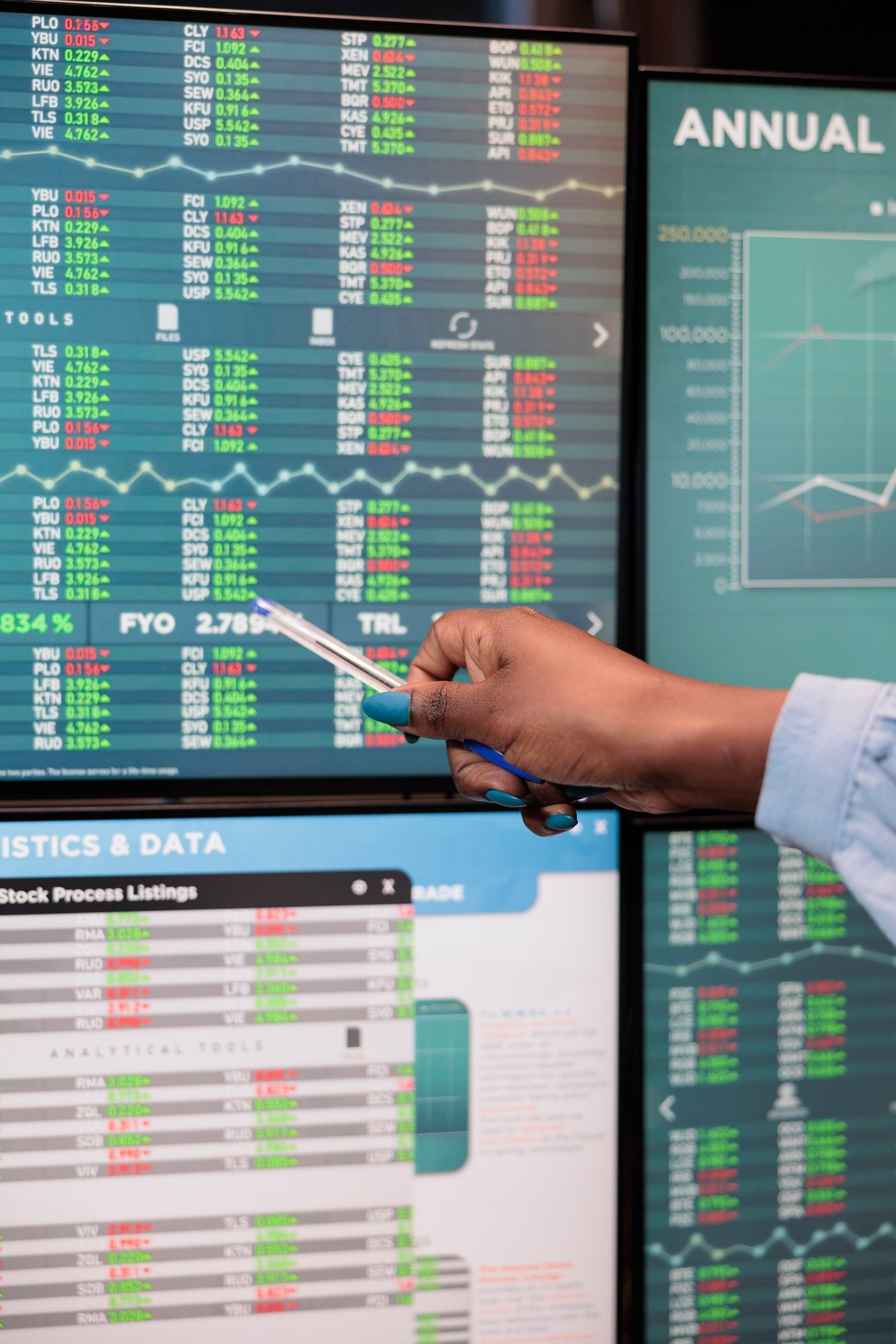 Close up shot of forex stock market trader woman pointing at screen showing real time trading data.